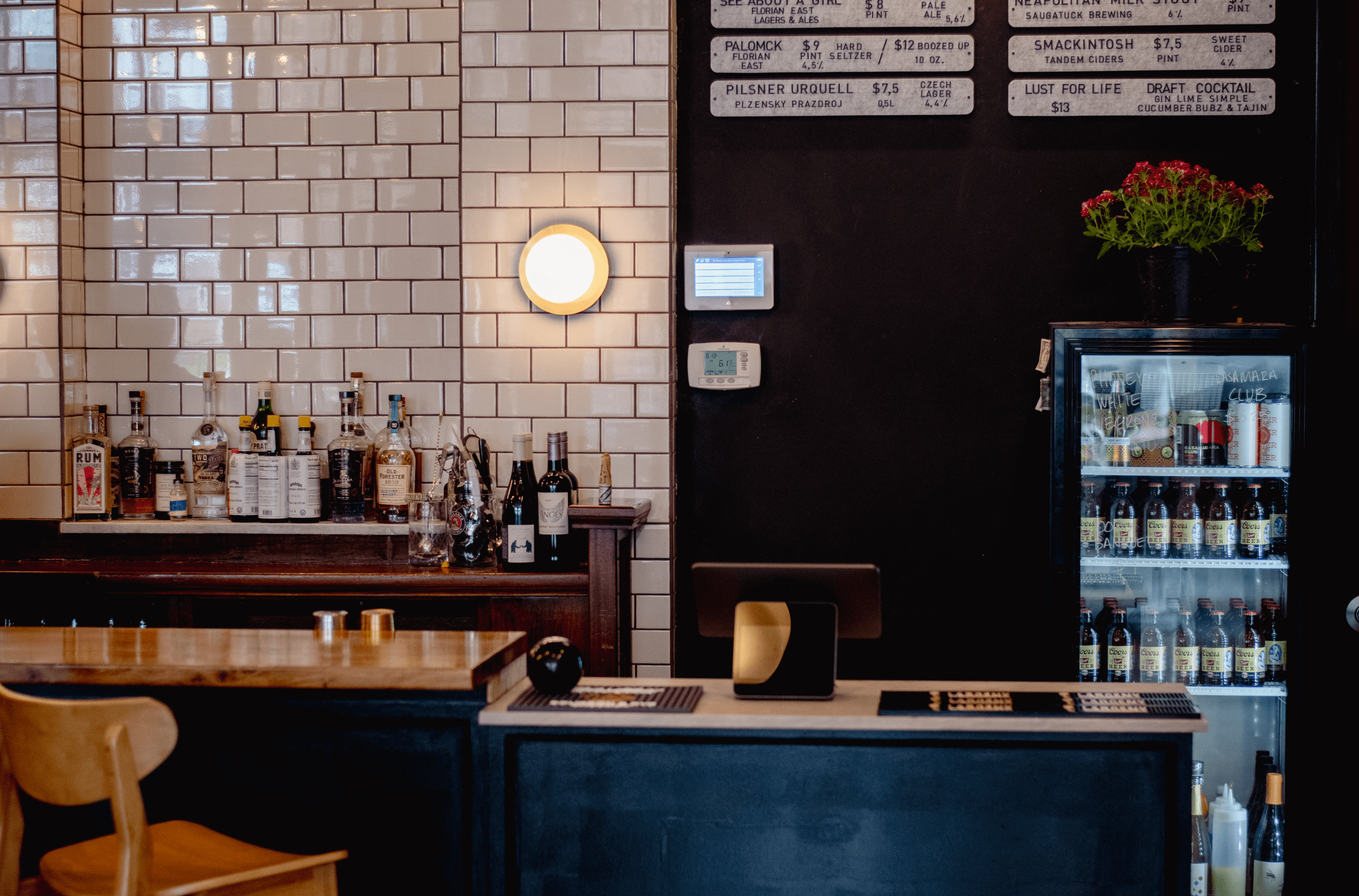 Subway tile along the back bar is next to a menu board at Meantime. 